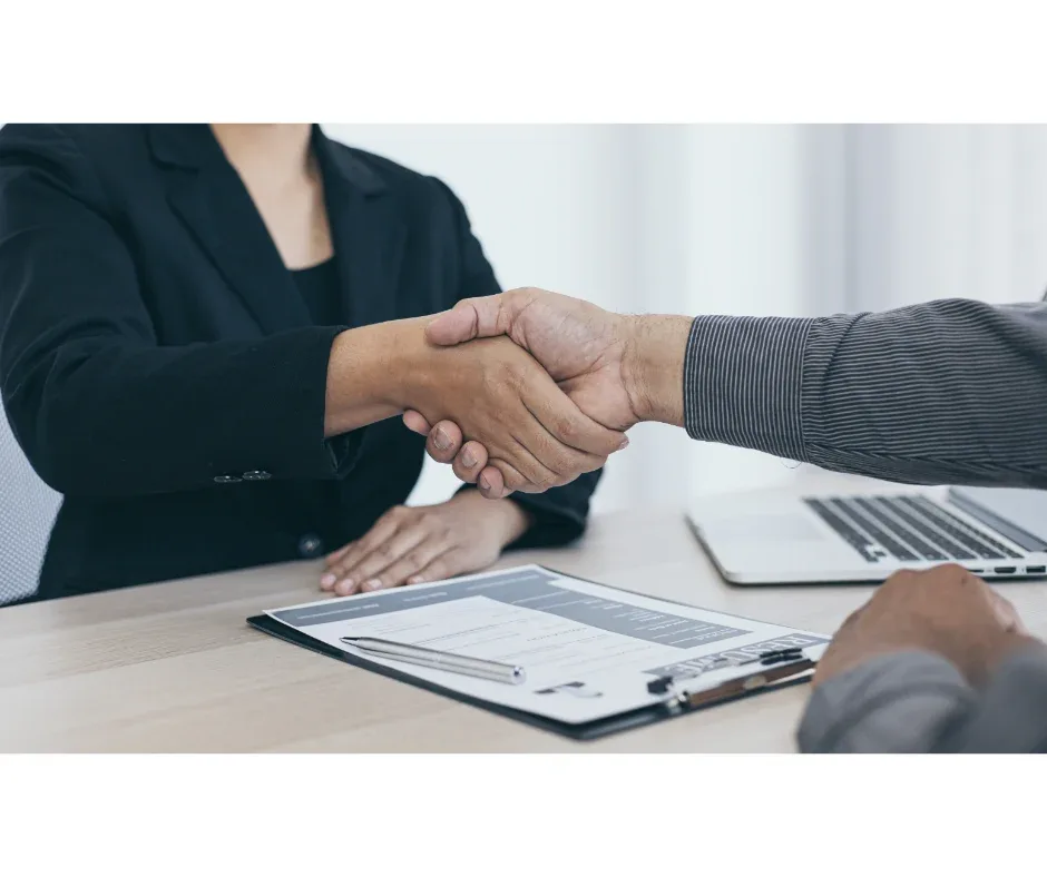Estágios de pós-graduação EaD: como ajudam na prática? | Foto de um homem e uma mulher dando as mãos para fechar um negócio | FAVENI