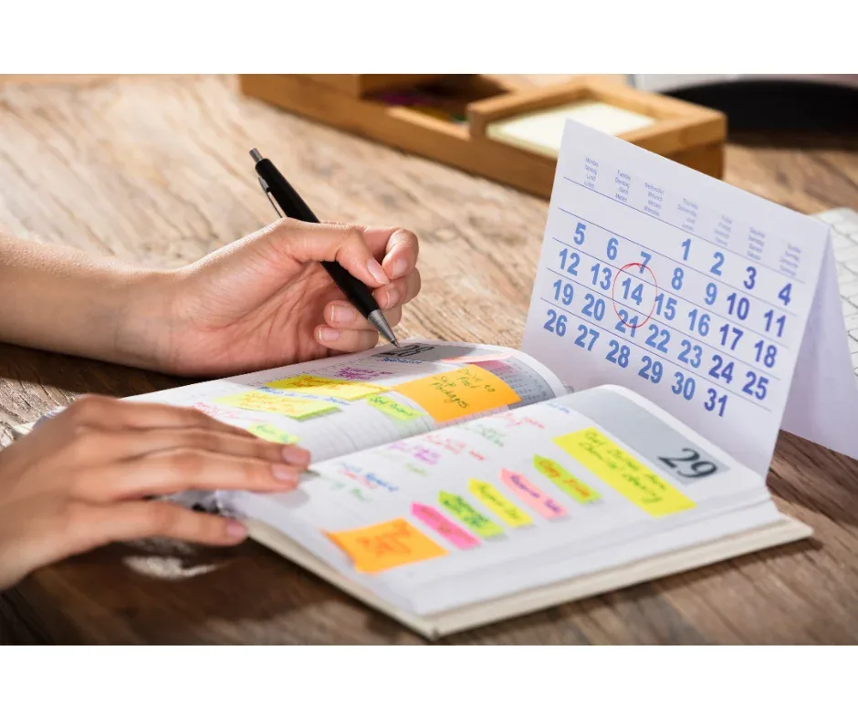 Flexibilidade na pós-graduação EaD: como gerenciar o estudo? | Pessoa anotando compromissos em uma agenda olhando um calendário | FAVENI