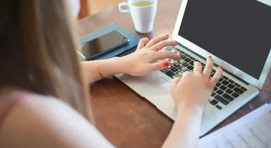 Motivos para as pós EAD fazerem sucesso| Mulher mexendo em laptop| FAVENI