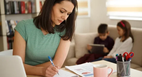 Prática na pós-graduação EaD: como são feitas as atividades? | Mãe estudando em casa com seus filhos no sofá | FAVENI