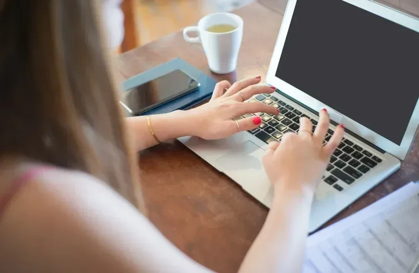 Motivos para as pós EAD fazerem sucesso| Mulher mexendo em laptop| FAVENI